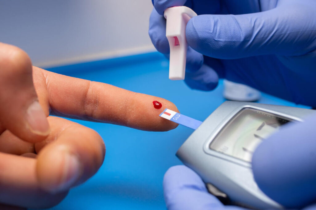 Closeup shot of a doctor with rubber gloves taking a blood test for cholesterol from a patient